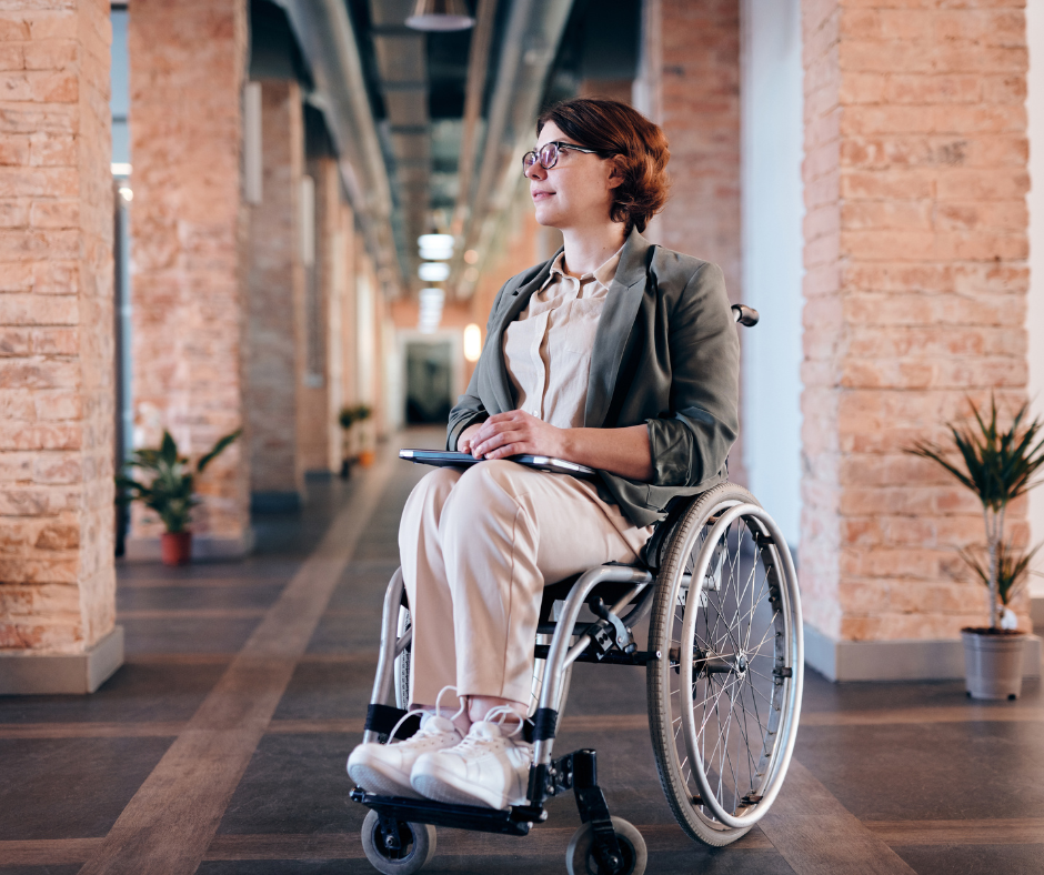 woman sitting in wheelchair outside a building with laptop