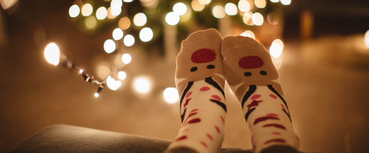 Christmas socks on feet in front of tree