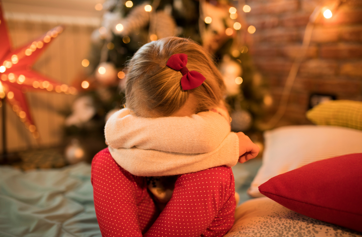 Young girl pouting in front of Christmas tree
