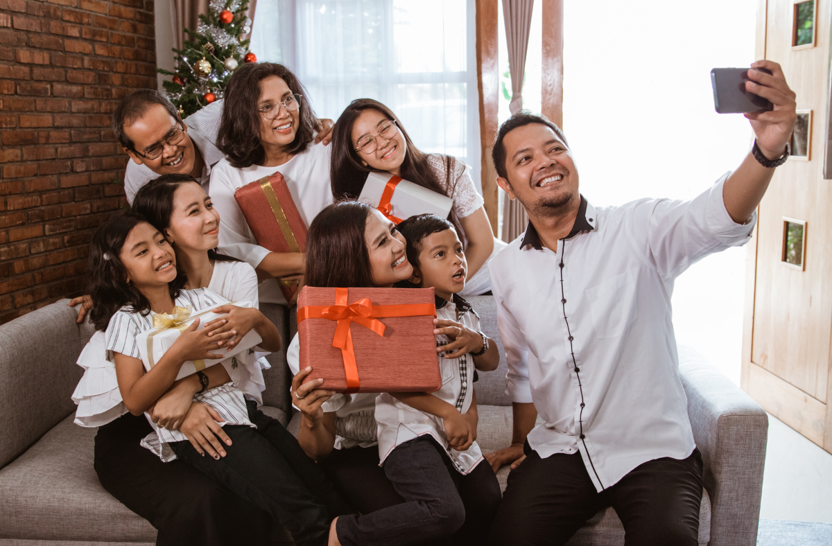 Family holding Christmas gifts taking selfie