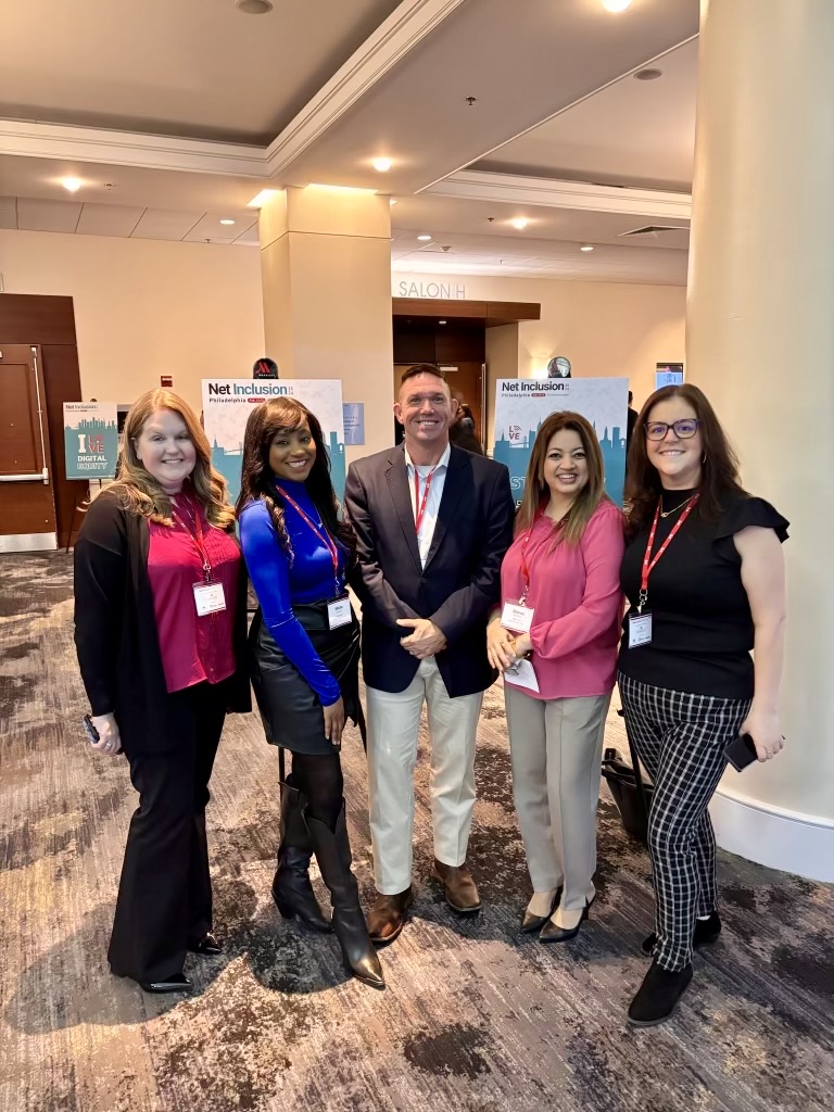 5 professionals standing and smiling for camera at Net Inclusion Conference