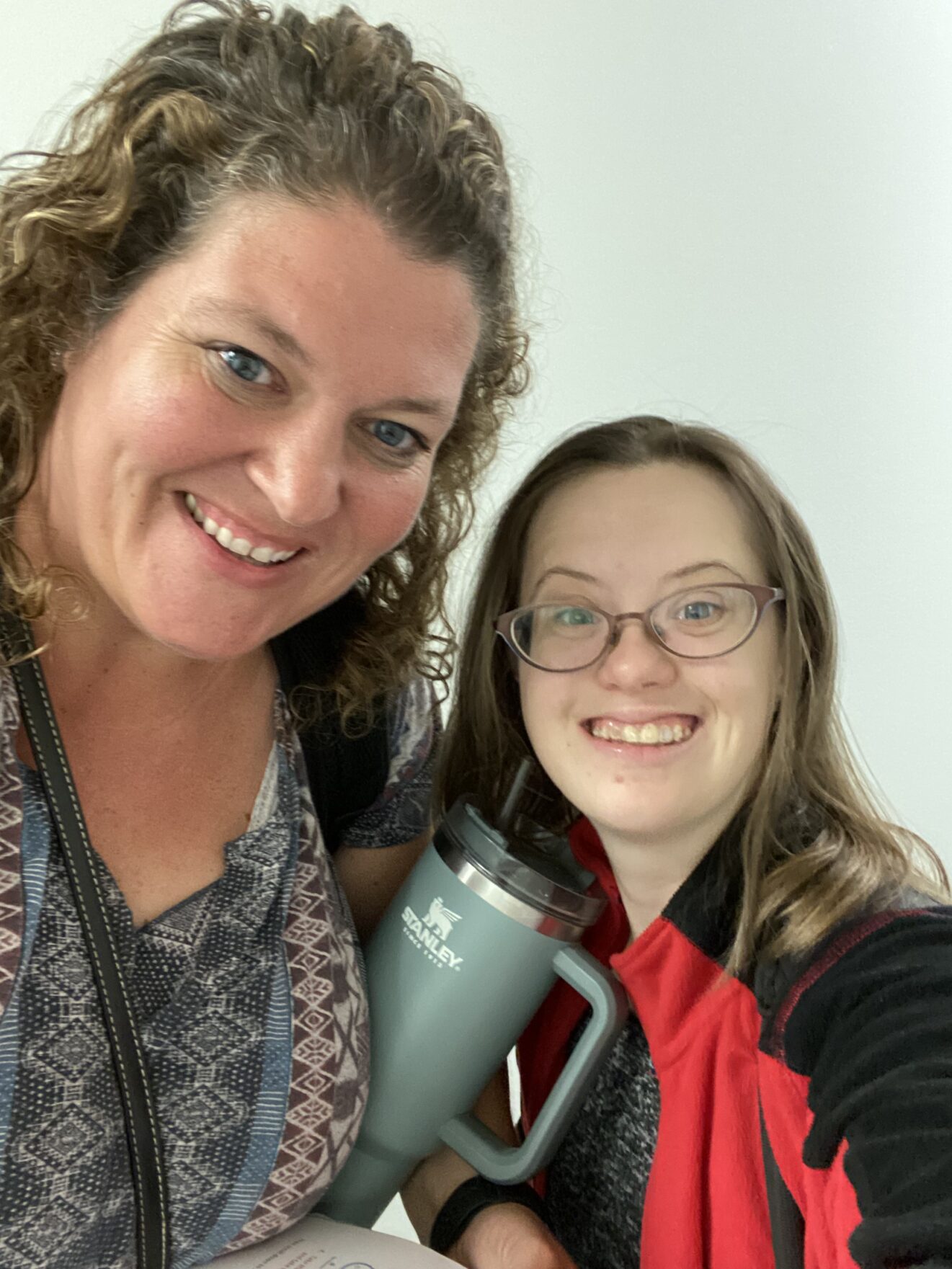 woman and young adult woman with Down syndrome smiling at the camera