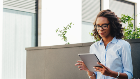young adult woman sitting in office using ipad