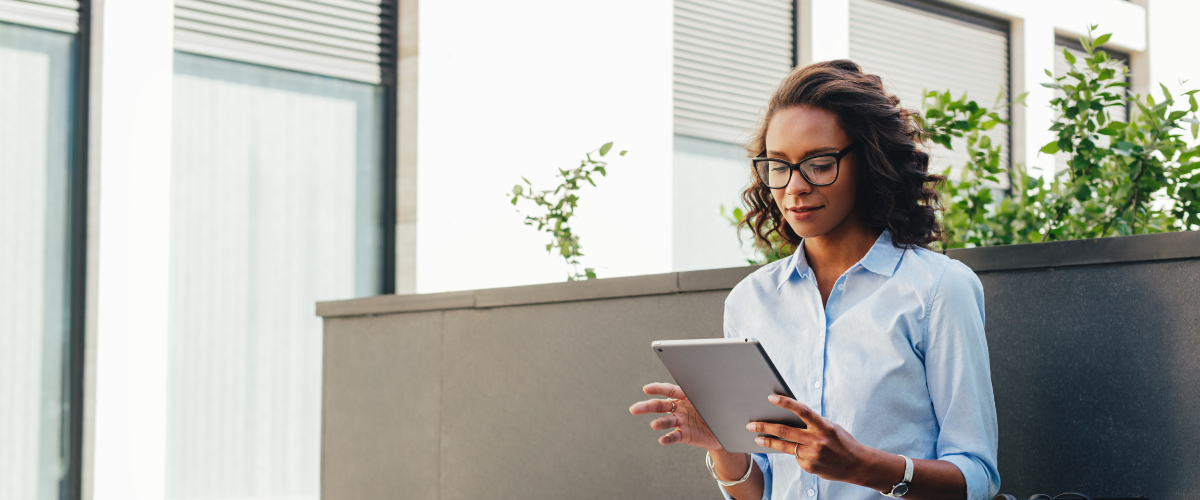 young adult woman sitting in office using ipad