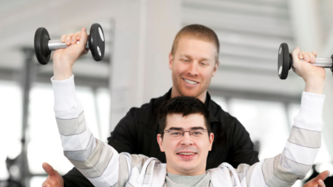 young man sitting in wheelchair working out in gym