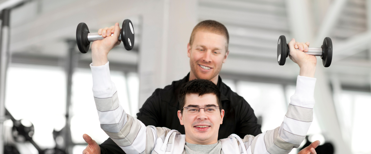 young man sitting in wheelchair working out in gym