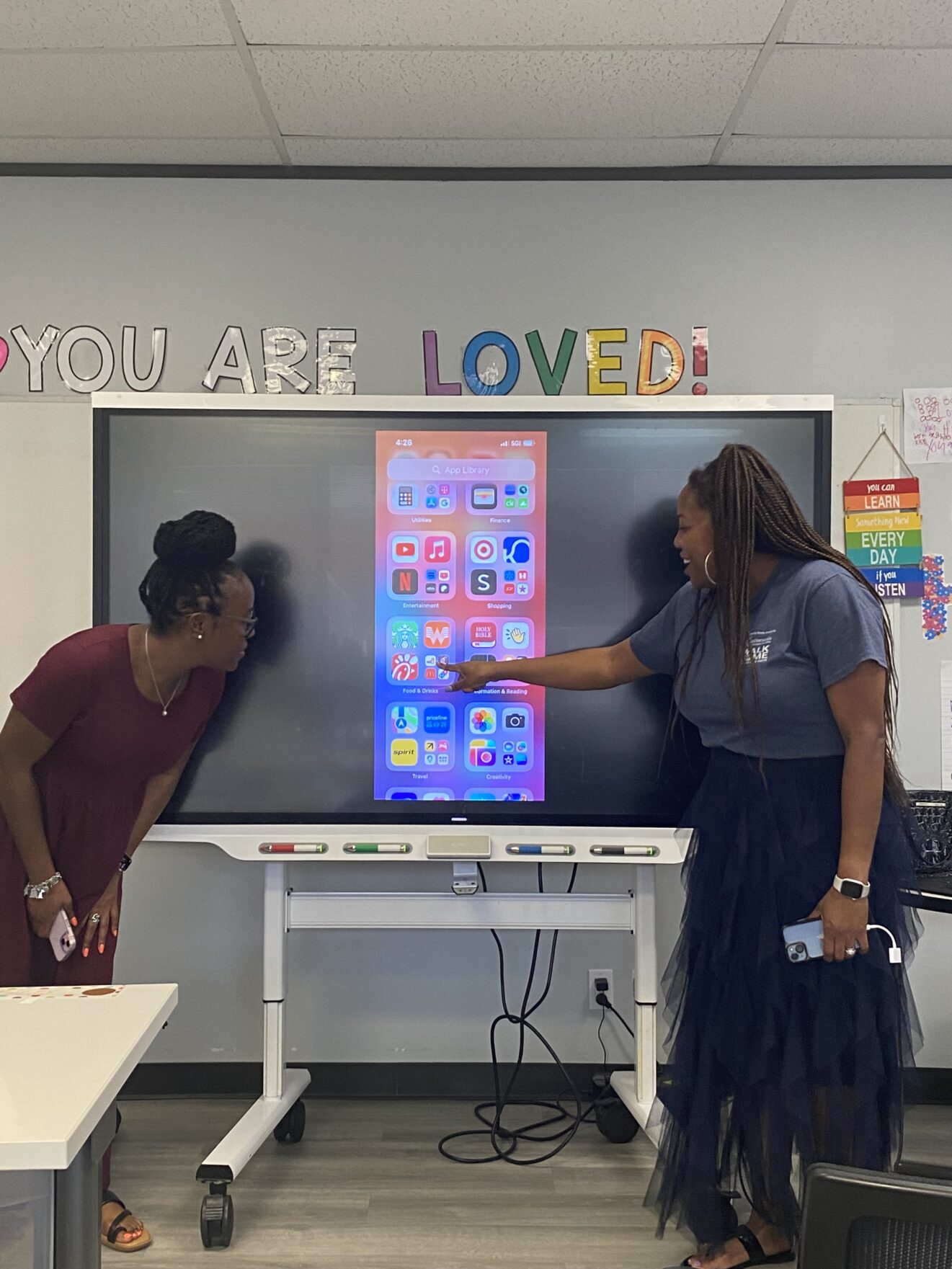 2 teachers instructing classroom using a smart board