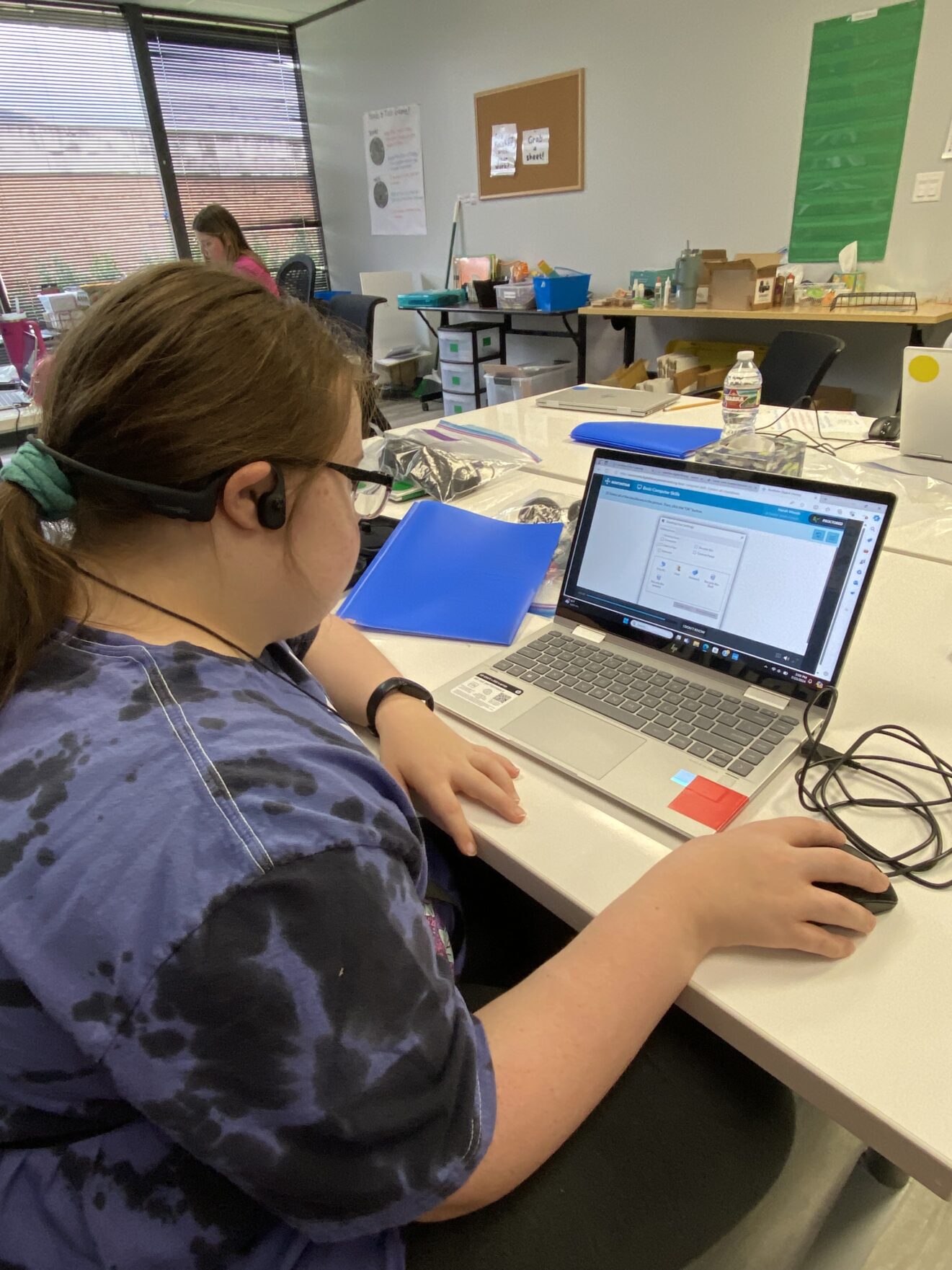 young lady working on laptop in classroom