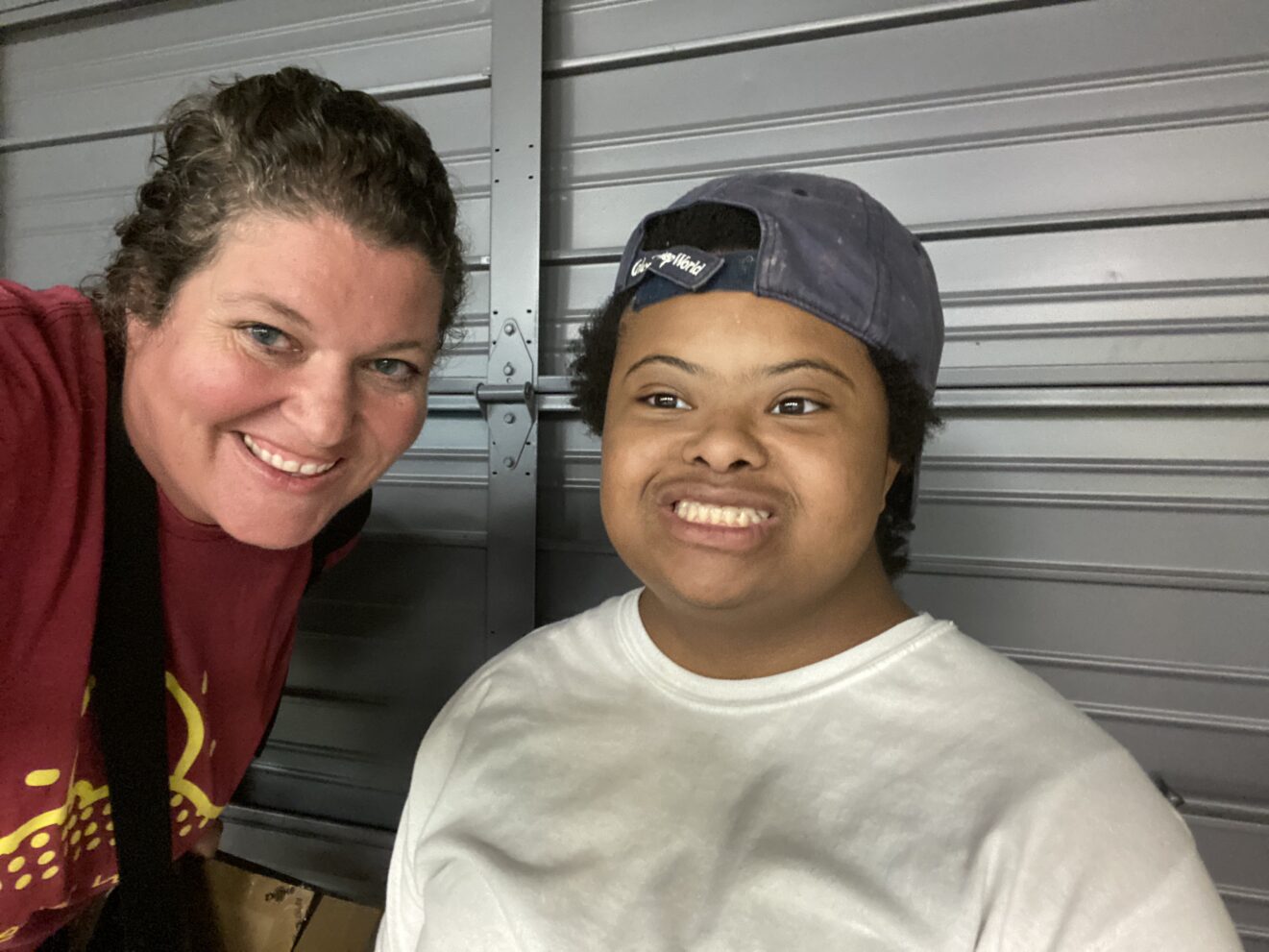 teacher and student smiling at camera