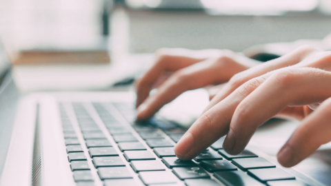 close up image of hands typing on a laptop