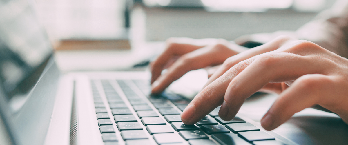 close up image of hands typing on a laptop