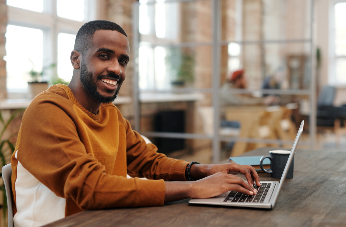 man sitting at computer smiling at camera