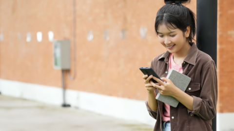 teen girl using phone outside