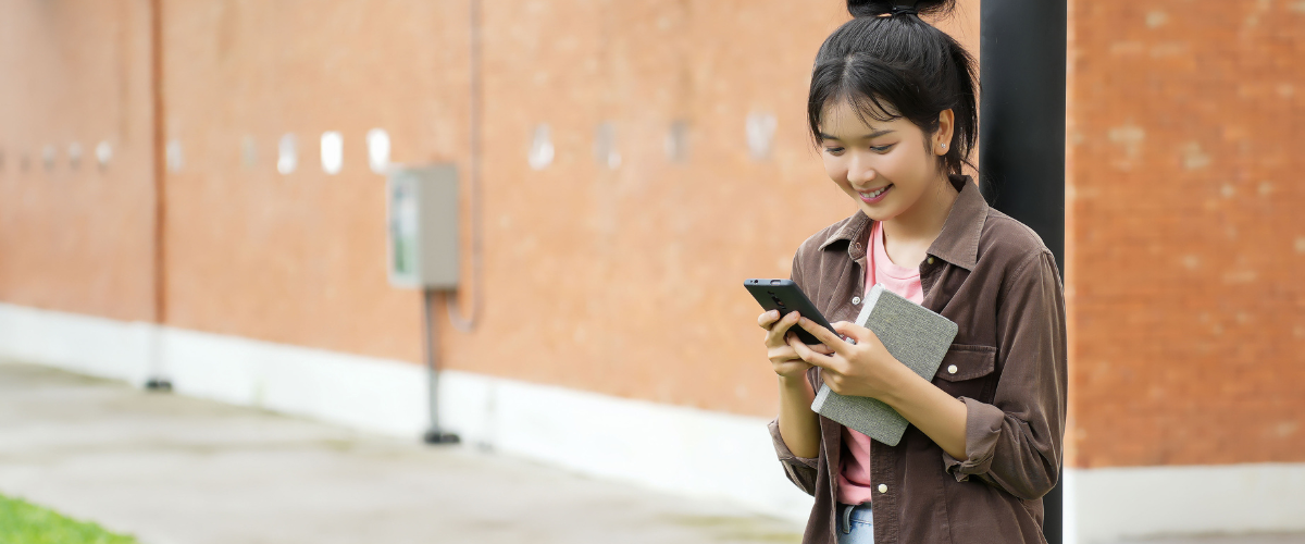 teen girl using phone outside