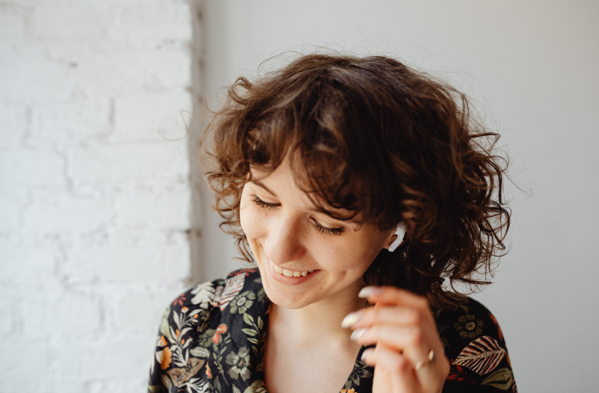 young adult female putting airpod in ear