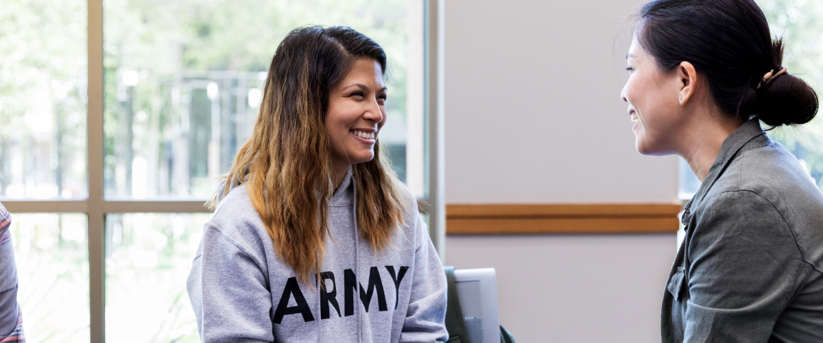 woman wearing grey hoodie talking to another women