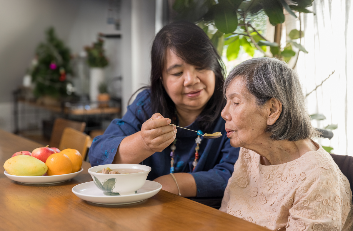 woman spoon feeding another woman