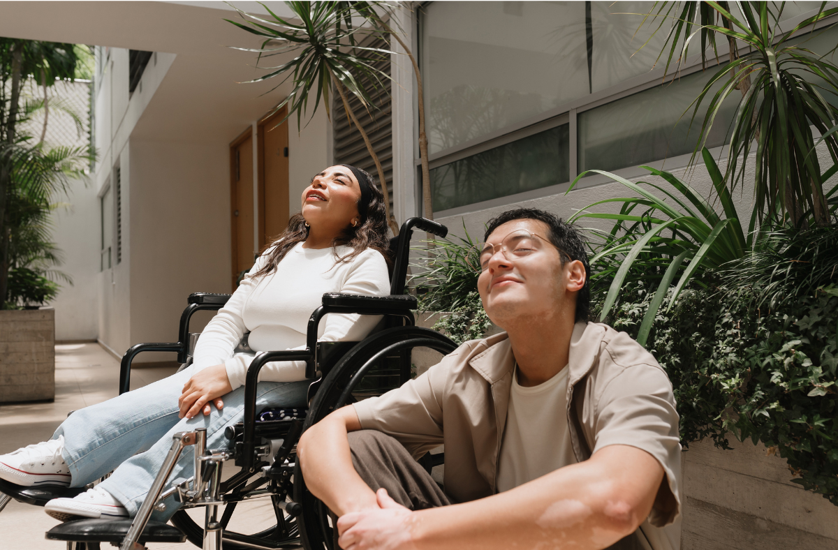 girl in wheelchair sitting next to friend outside