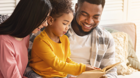 mom and dad reading with young girl