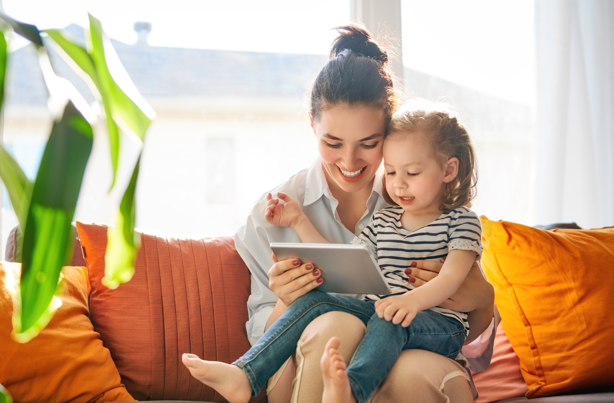 lady and young girl looking at tablet device together smiling