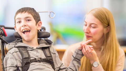 young man in wheelchair with therapist or teacher