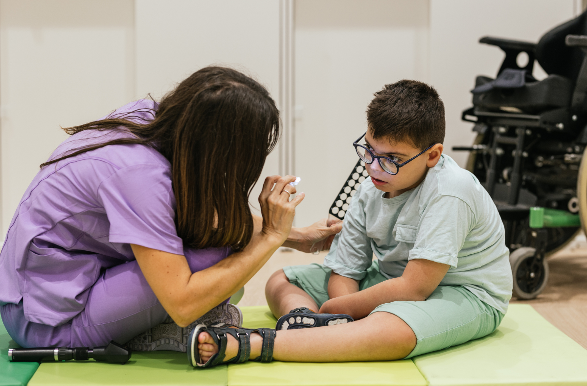 child sitting on floor with therapist