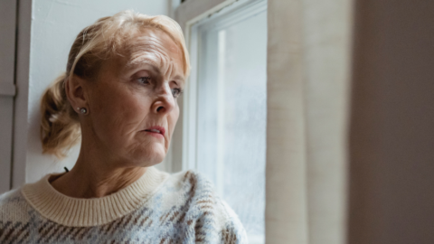 older woman looking out window