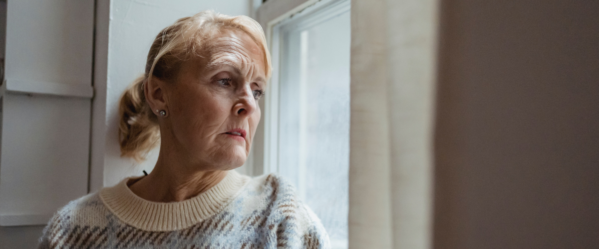 older woman looking out window