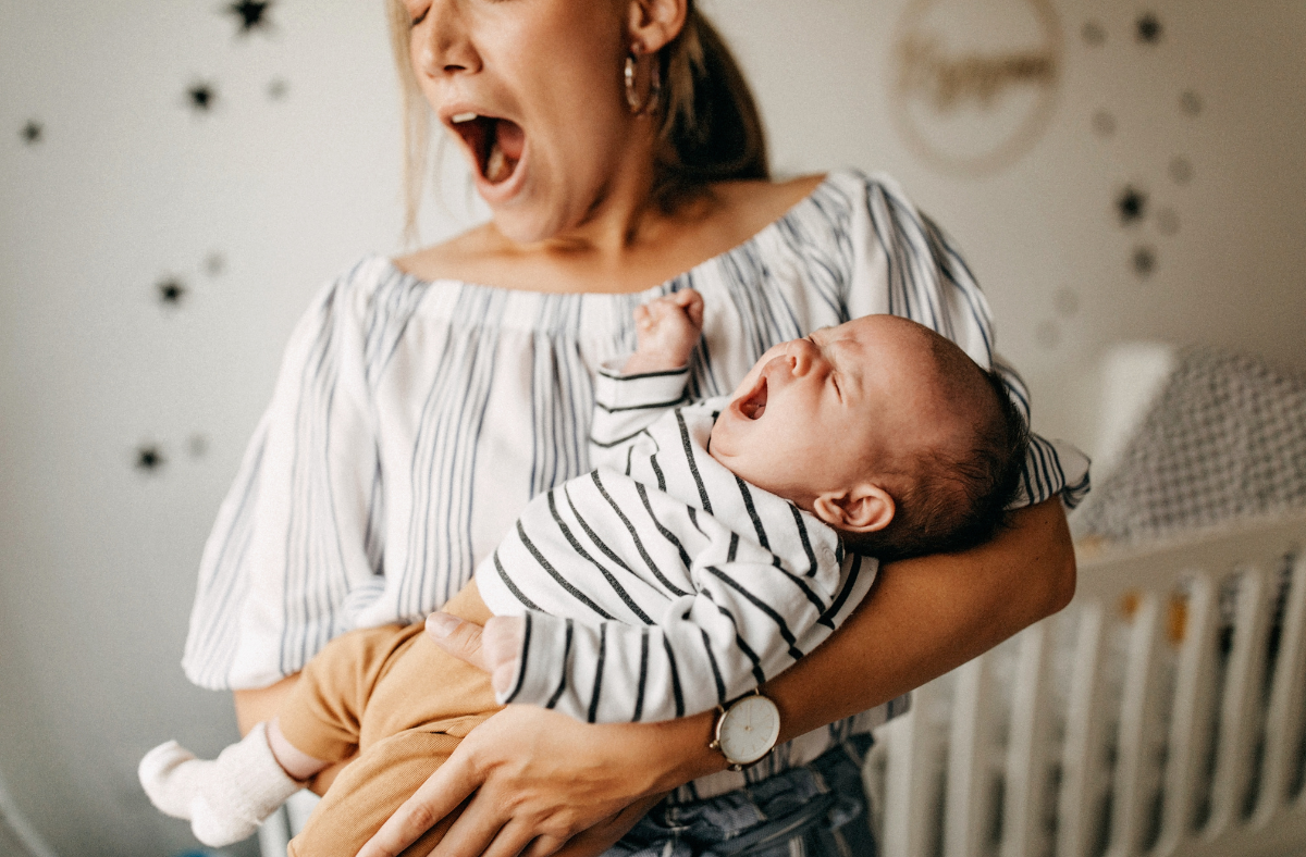 mom holding baby, they're both yawning