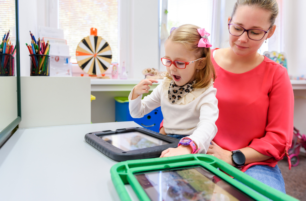 therapist with child using aac on an ipad