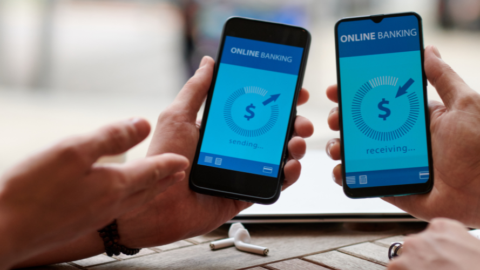 2 hands holding phones with mock bank app on screen