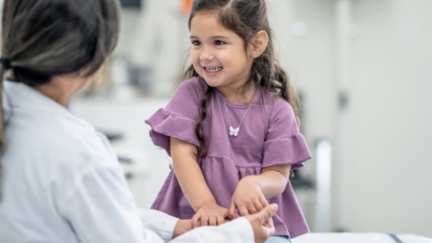 girl sitting with health provider in office