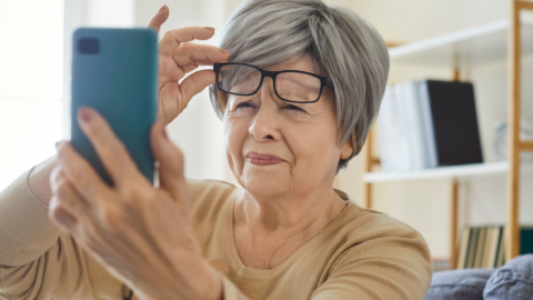 Older adult woman squinting at phone