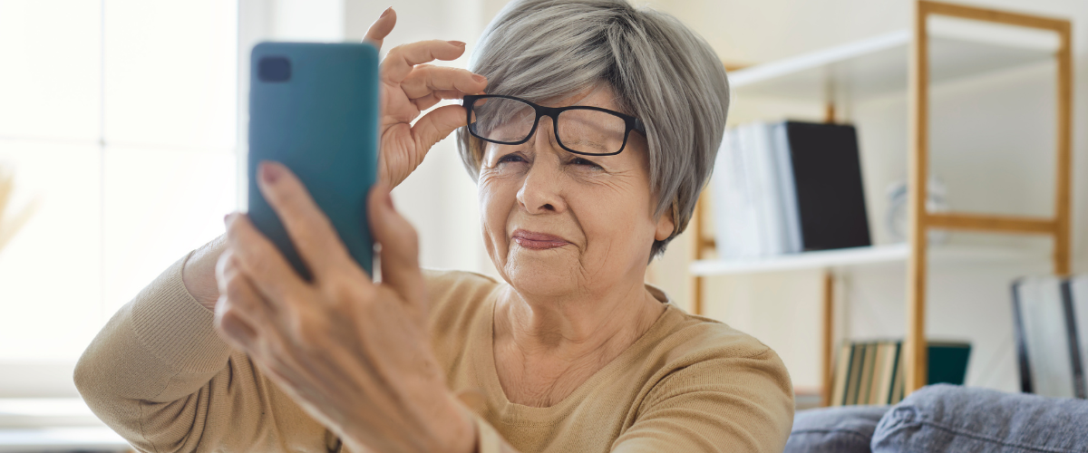 Older adult woman squinting at phone