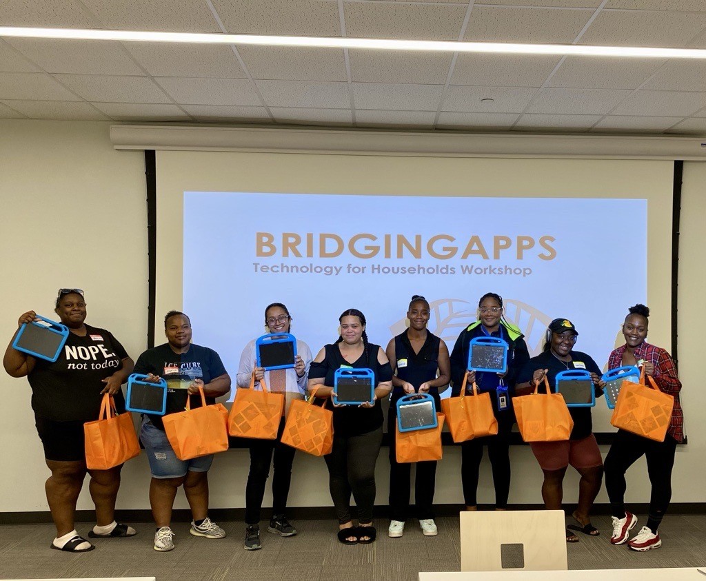 group of elqn participatnts standing in front of classrooms holding orange bags