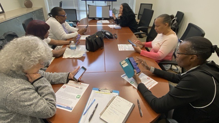 group of women sitting at table using smart phones